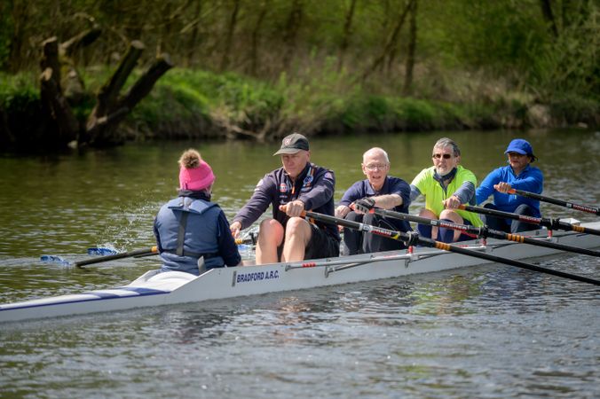 Mature people rowing in river