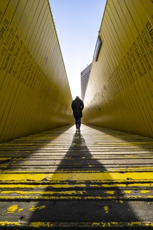 Person walking on yellow wooden pathway