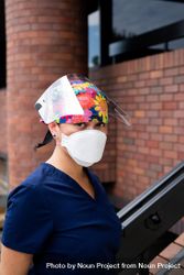 Portrait of nurse in front of hospital in PPE looking at camera 4BalW5
