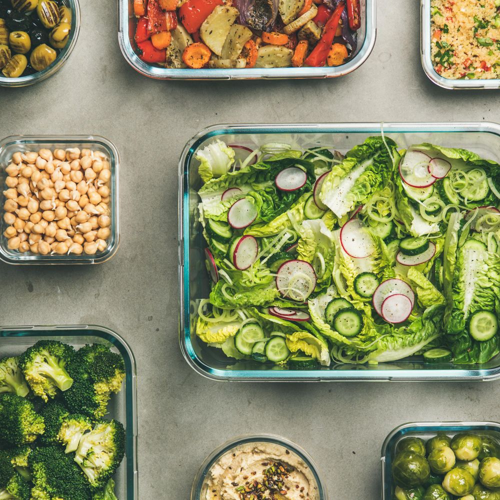 Variety of vegetable dishes arranged in glass containers, close up, square crop