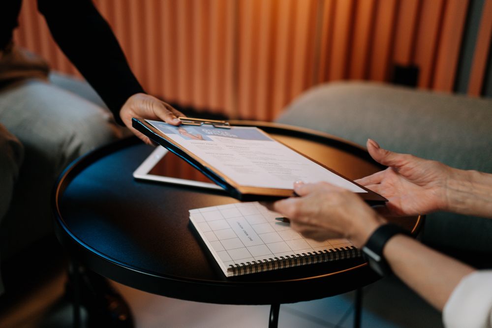 Cropped image of a person handing a file to a person