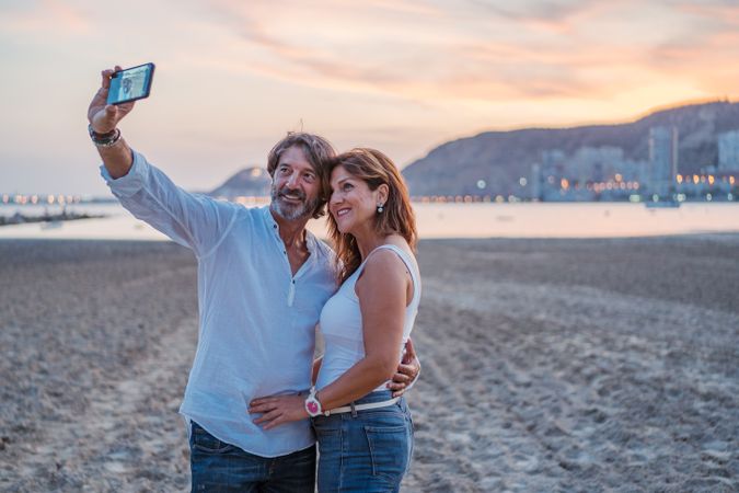 Adult couple taking selfie on beach