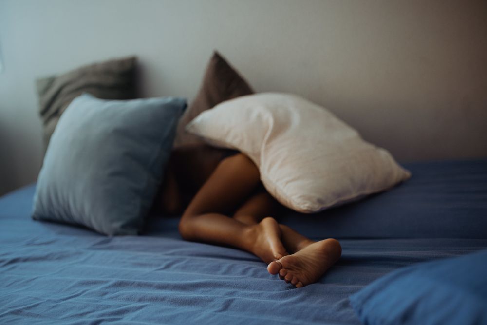 Anonymous kid lying under pillows
