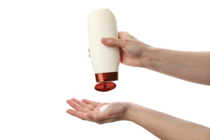 Female hands squeezing shampoo from bottle