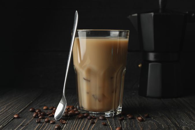 Composition with ice coffee and coffee seeds on wooden background