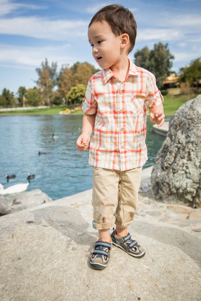 Young Biracial Chinese and White Boy Having Fun at the Park and Duck Pond.