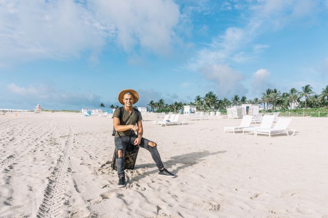 Very handsome young man looking at the camara, posing on the beach