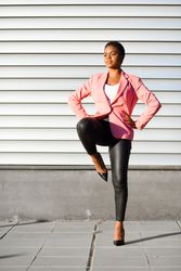 Female in modern business suit standing on one leg outside