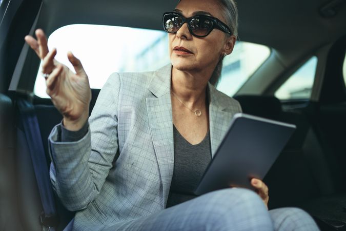 Female business executive traveling by a car