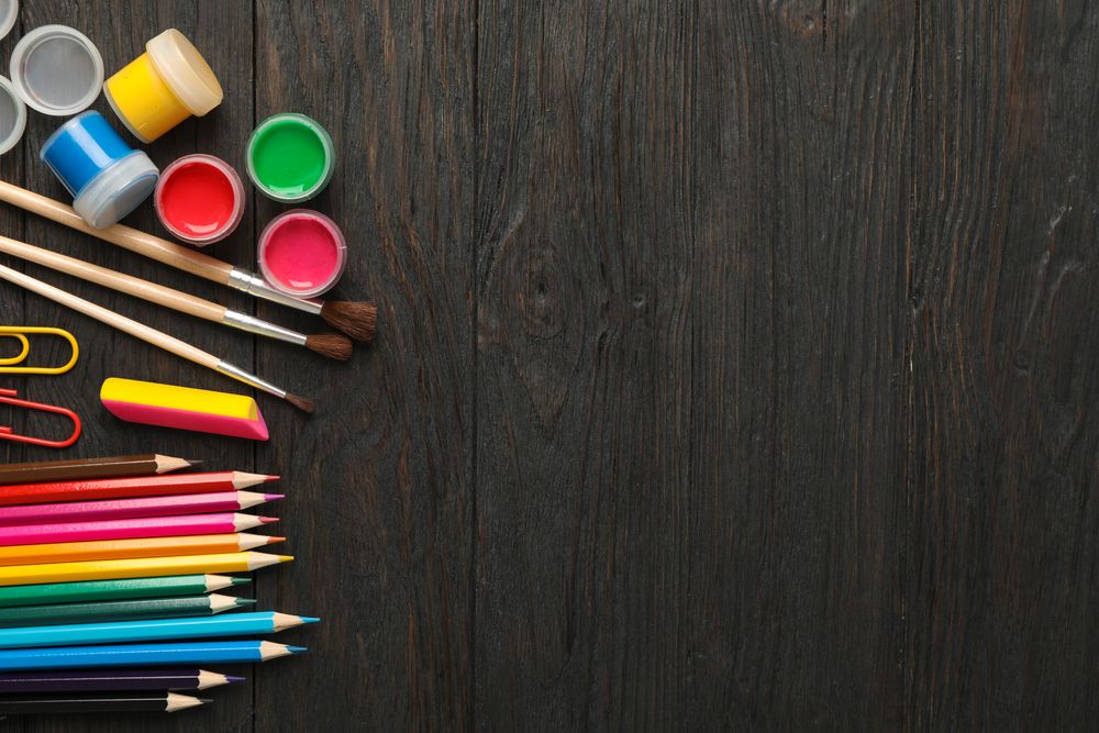 Flat lay composition with school supplies on wooden background, space for text