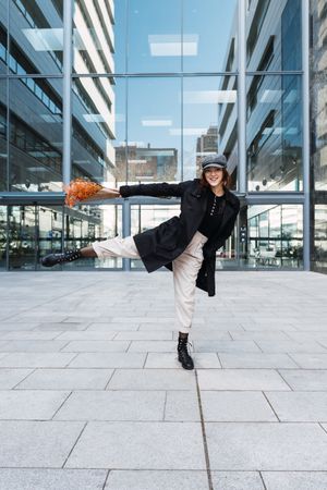 Happy woman with flowers dancing on street