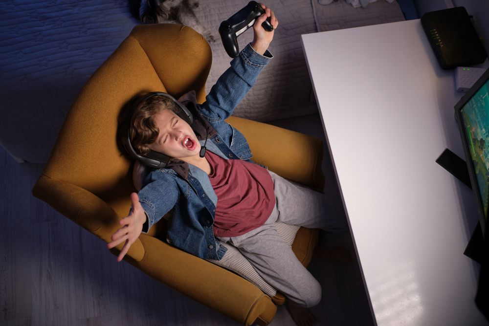 Expressive boy celebrating victory while playing videogame
