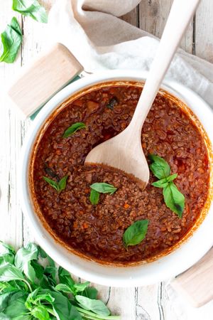 Pan with ragout Bolognese on wooden table