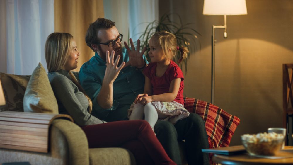 In the Evening Family Spends Time Together Sitting on a Couch in a Living Room.