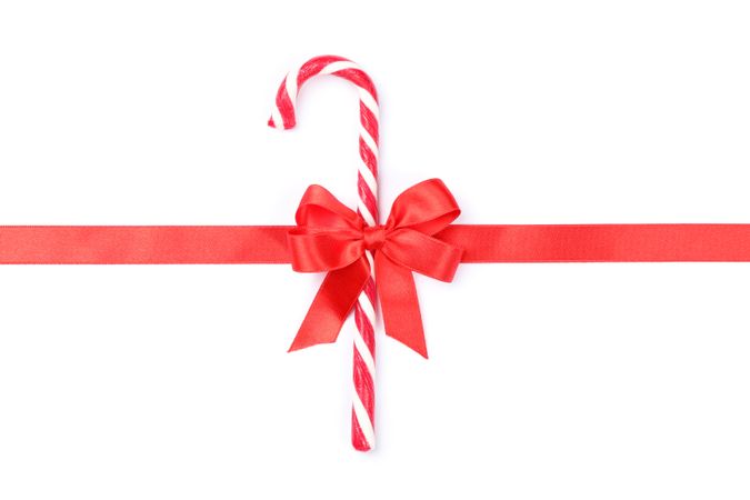 Sweet candy cane with bow isolated on plain background
