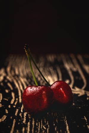 Red ripe cherry with stem on wooden stand