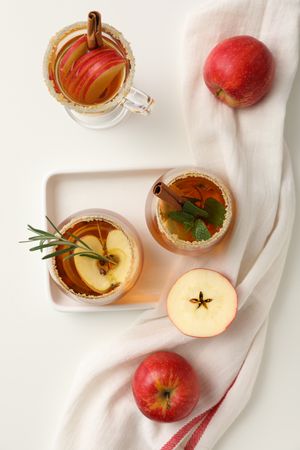 Glasses with apple cider and red apples, top view