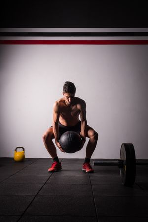 Man throwing ball on wall in gym