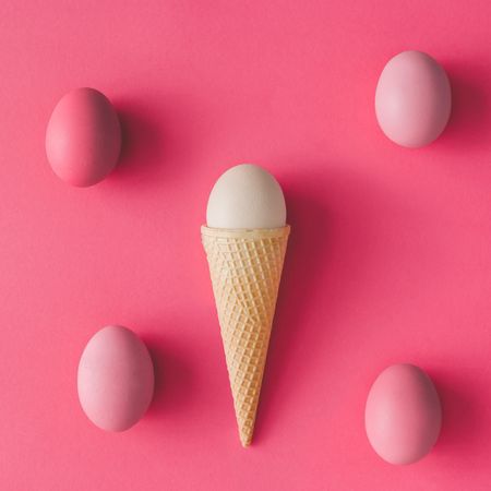 Ice cream cone with eggs on pink background