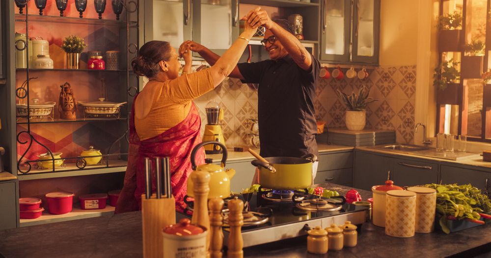 Energetic and Happy Mature Couple Dancing and Having Fun in the Kitchen: Celebrating Life, Vitality and Youthful Spirit.