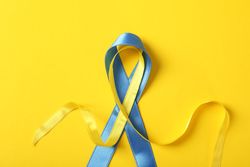 Ribbon in Ukrainian flag colors on yellow background