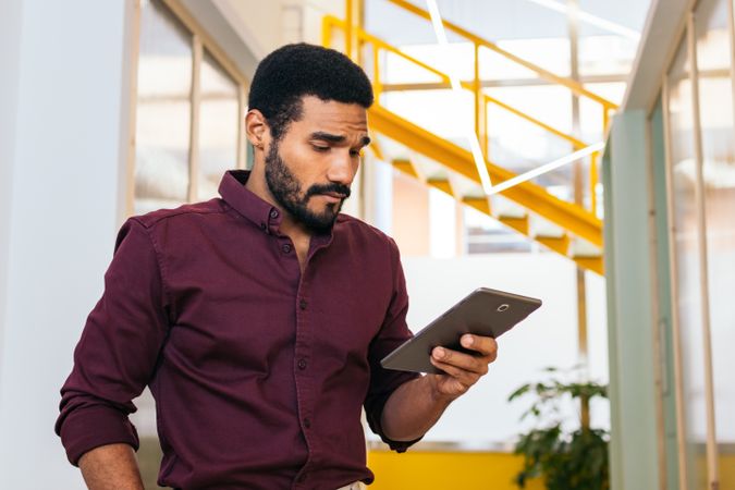 Handsome man in shirt working with a tablet in a coworking