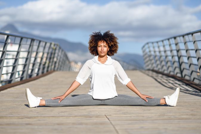 Woman doing side splits on bridge
