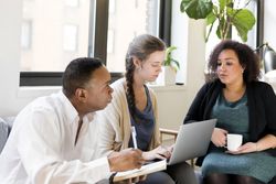 Two women and man discussing work