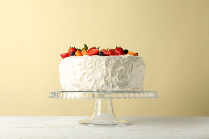 Berry cream cake on wooden table. Delicious dessert