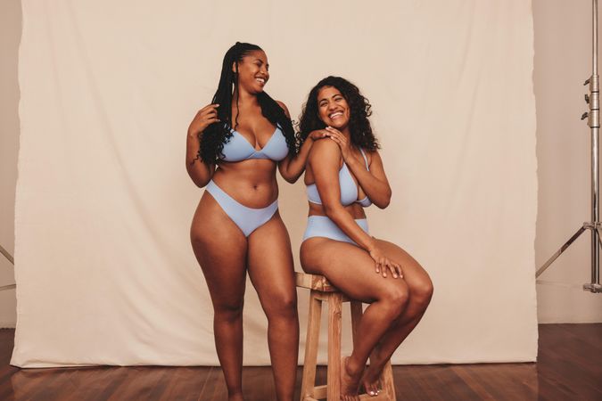 Two friends modeling in blue underwear feeling happy