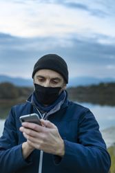 Man in blue jacket holding phone