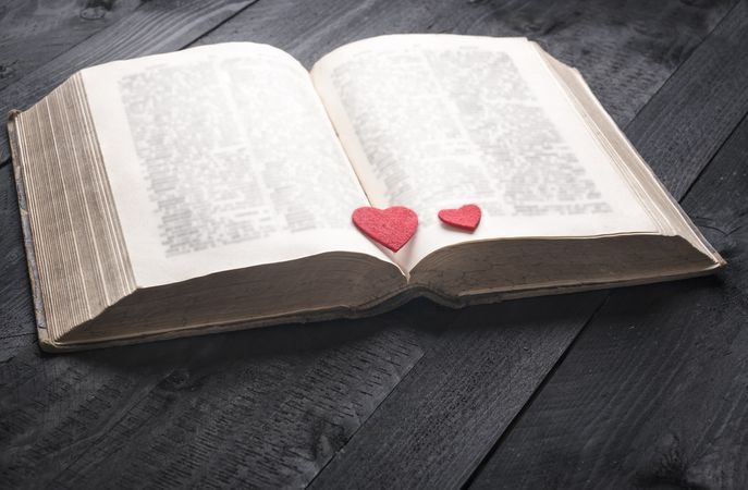 Two red hearts on an aged book