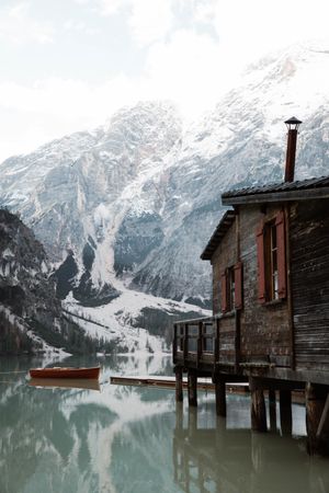 House on stilts on lake near mountains