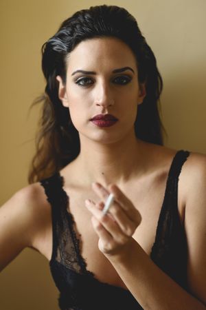 Brunette female wearing lace top with a cigarette