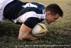 Strong rugby player with ball on ground during the game 4mnPQb