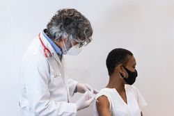 Doctor making injection for Black woman patient