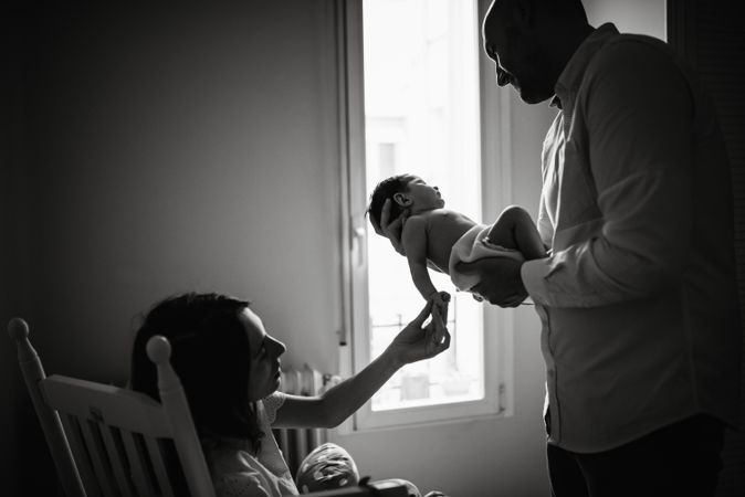 Parents holding baby in room