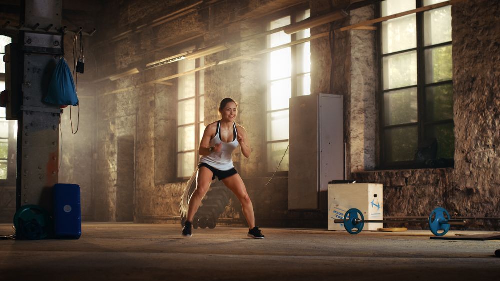 Fit Athletic Woman Does Footwork Running Drill in a Deserted Factory Remodeled into Gym.
