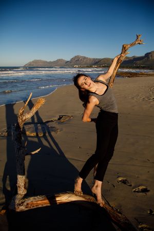 Young woman dancing and posing near water on shore