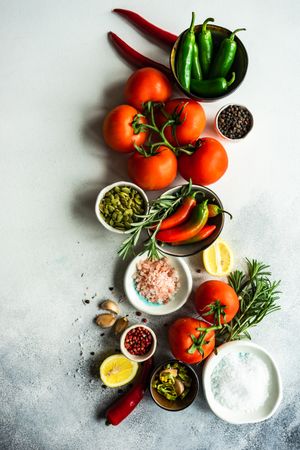 Top view of Himalayan salt & pumpkin seeds with tomatoes, garlic & herbs in center of counter