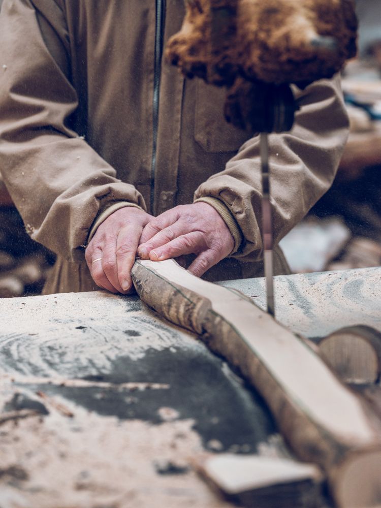 Unrecognizable carpenter cutting wooden piece