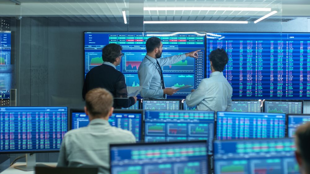 Three Experienced Stock Traders Talking Business, Consulting Documents and Argue About Data.