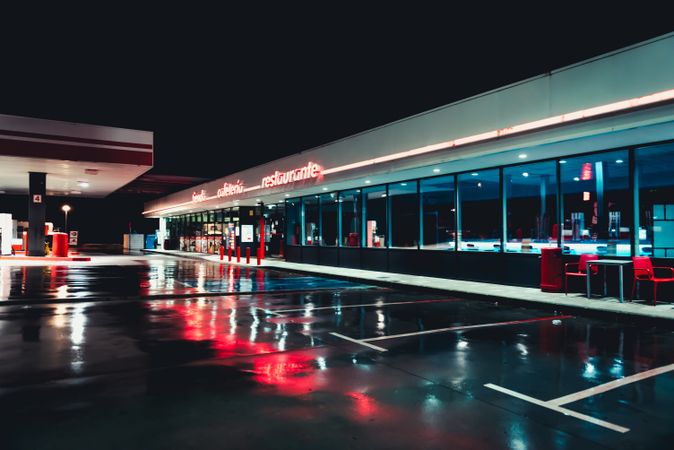 Empty retro gas station with cafe at night after rain