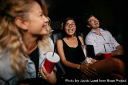Young woman with friends watching movie in cinema berOA0