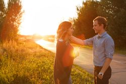 Man reaching for girlfriends cheek at sunset