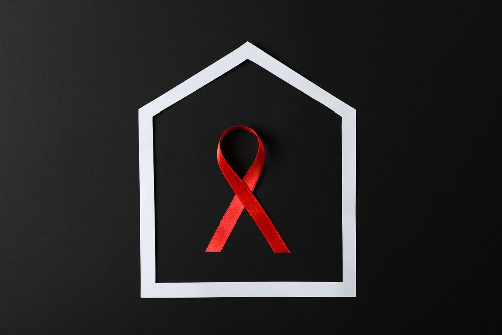 Awareness red ribbon in frame on dark background, copy space