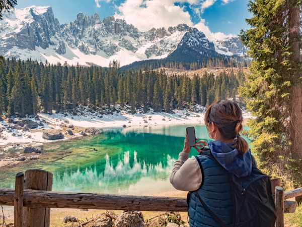 Woman in down vest taking photo of amazing landscape