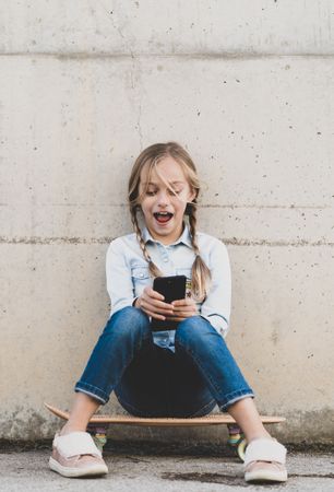 Kid using mobile phone with skate