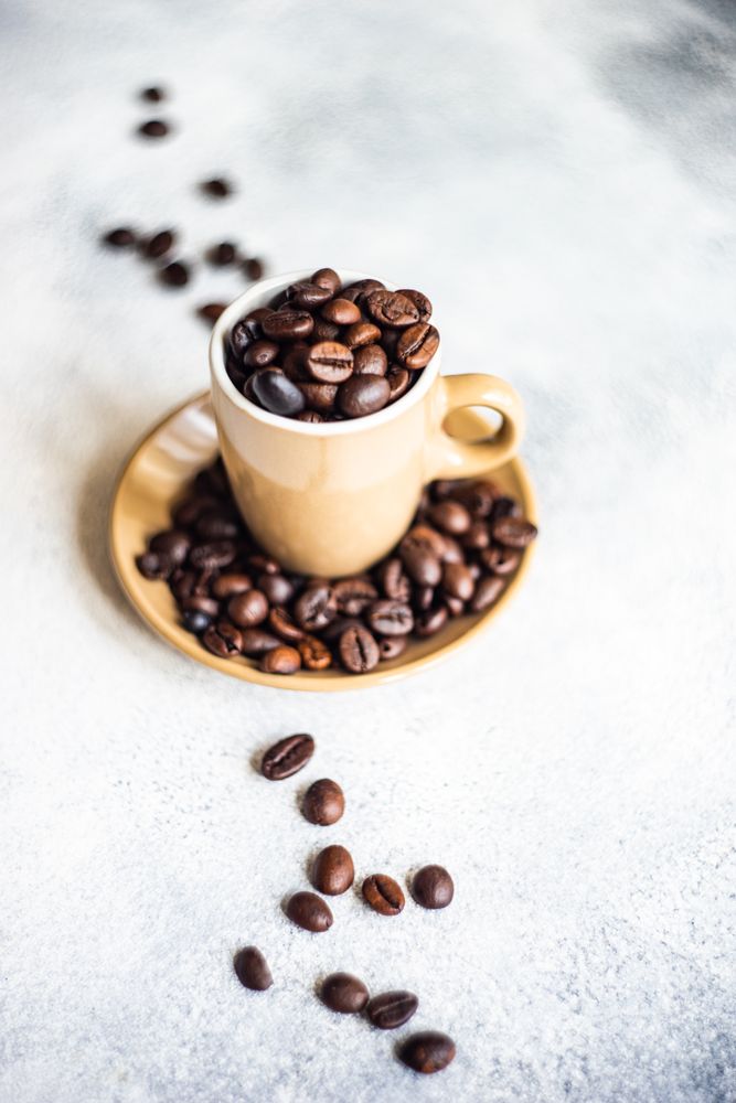 Espresso cup full of coffee beans