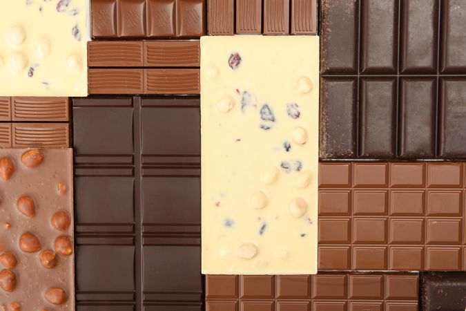 Different chocolate bars on whole background. Top view